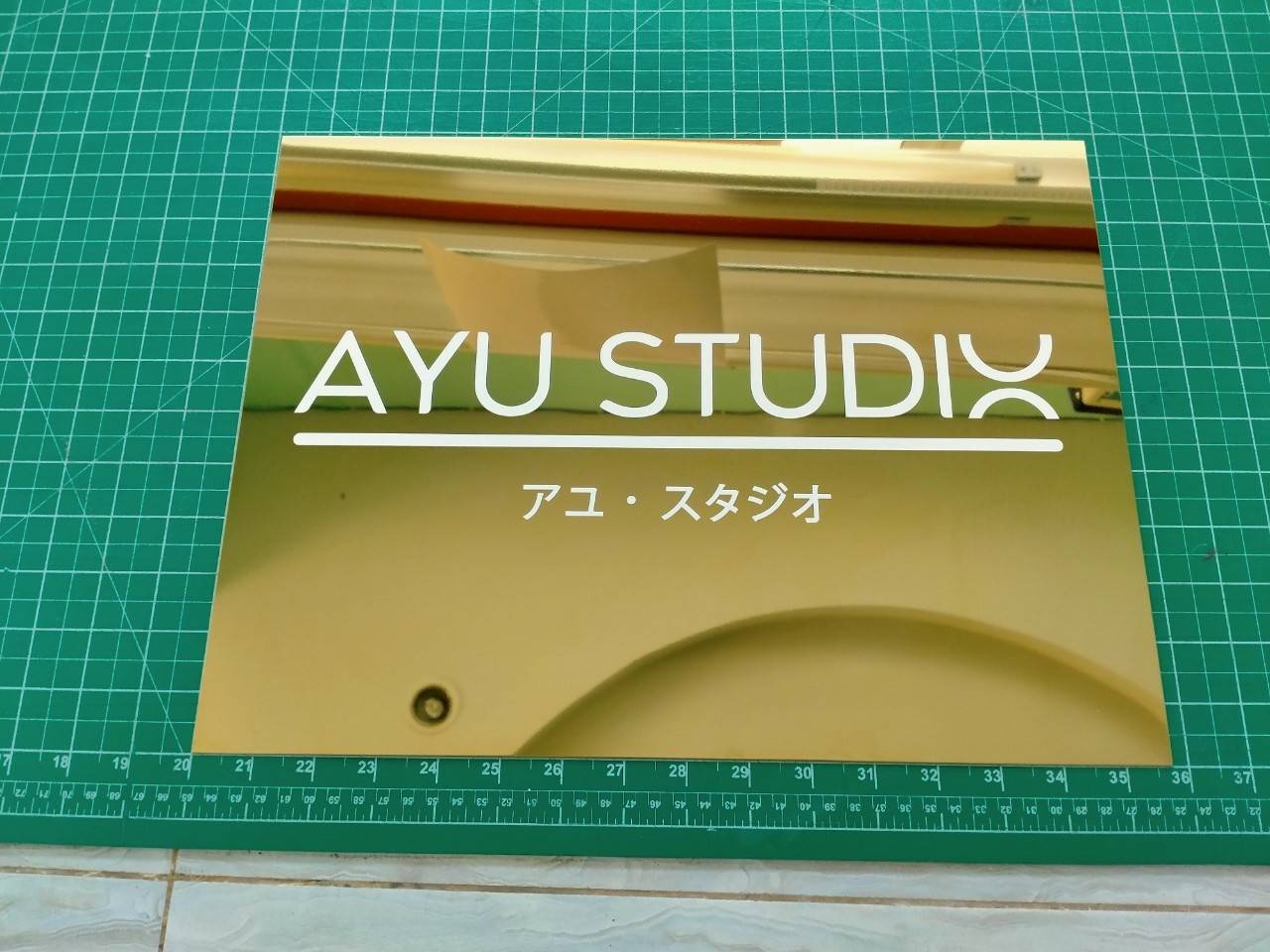 งานป้ายสแตนเลสสีทองหน้าเงา พิมพ์สกรีน สีขาว - AYU STUDX