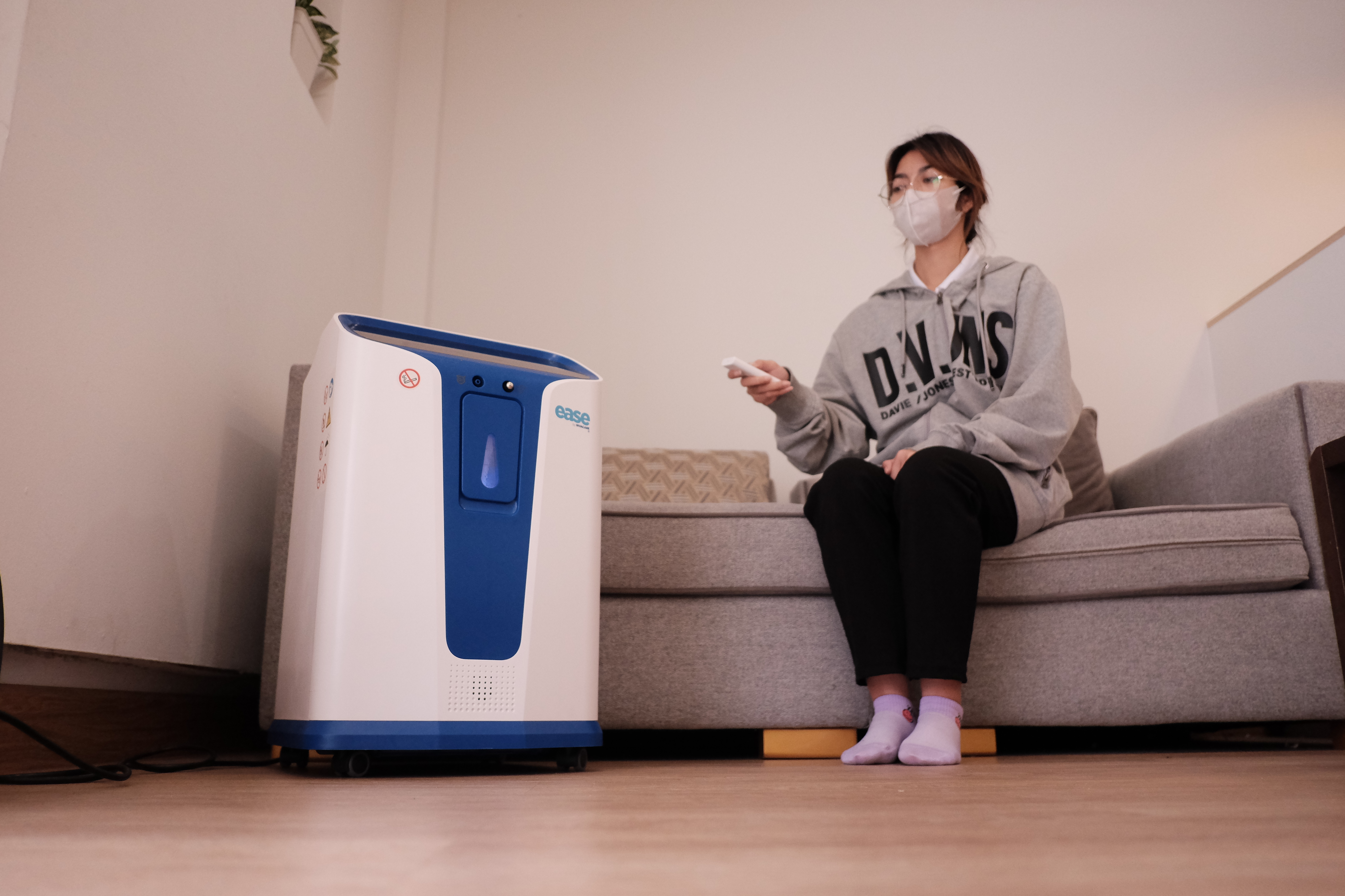 A person sitting on a couch wearing a face mask

Description automatically generated