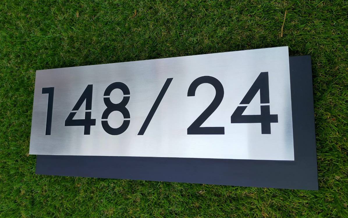 งานป้ายบ้านเลขที่ ฉะลุตัวเลข พื้นสแตนเลสแฮร์ไลน์สีเงินยกขอบ 2cm