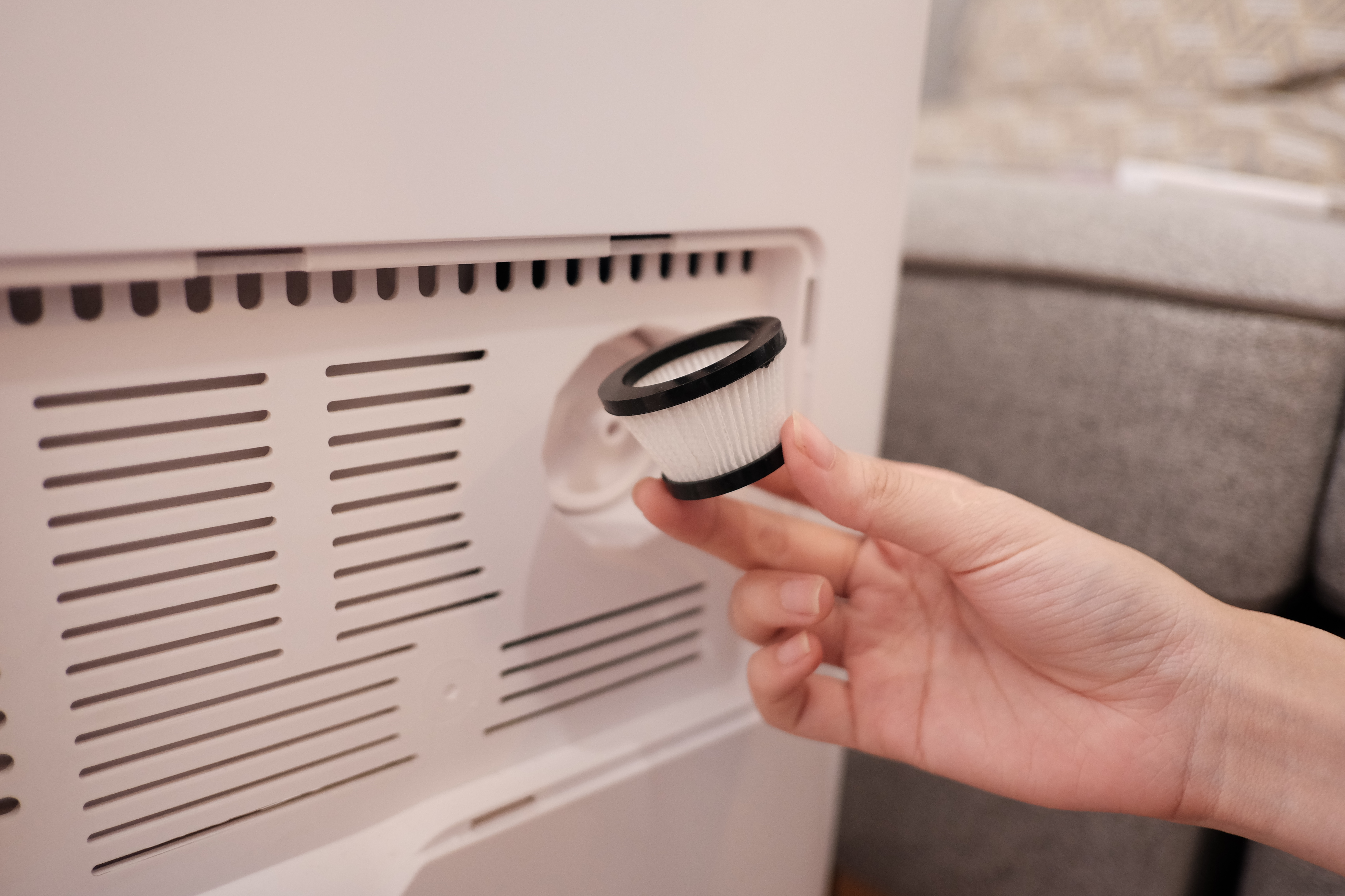 A person cleaning a air conditioner

Description automatically generated