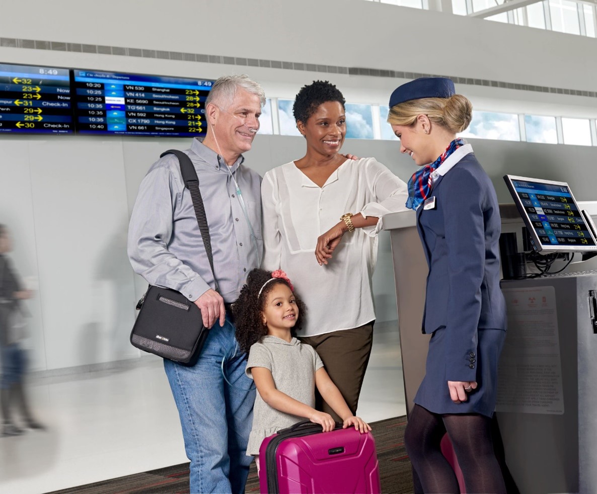 A group of people standing in front of a check-in counter

Description automatically generated