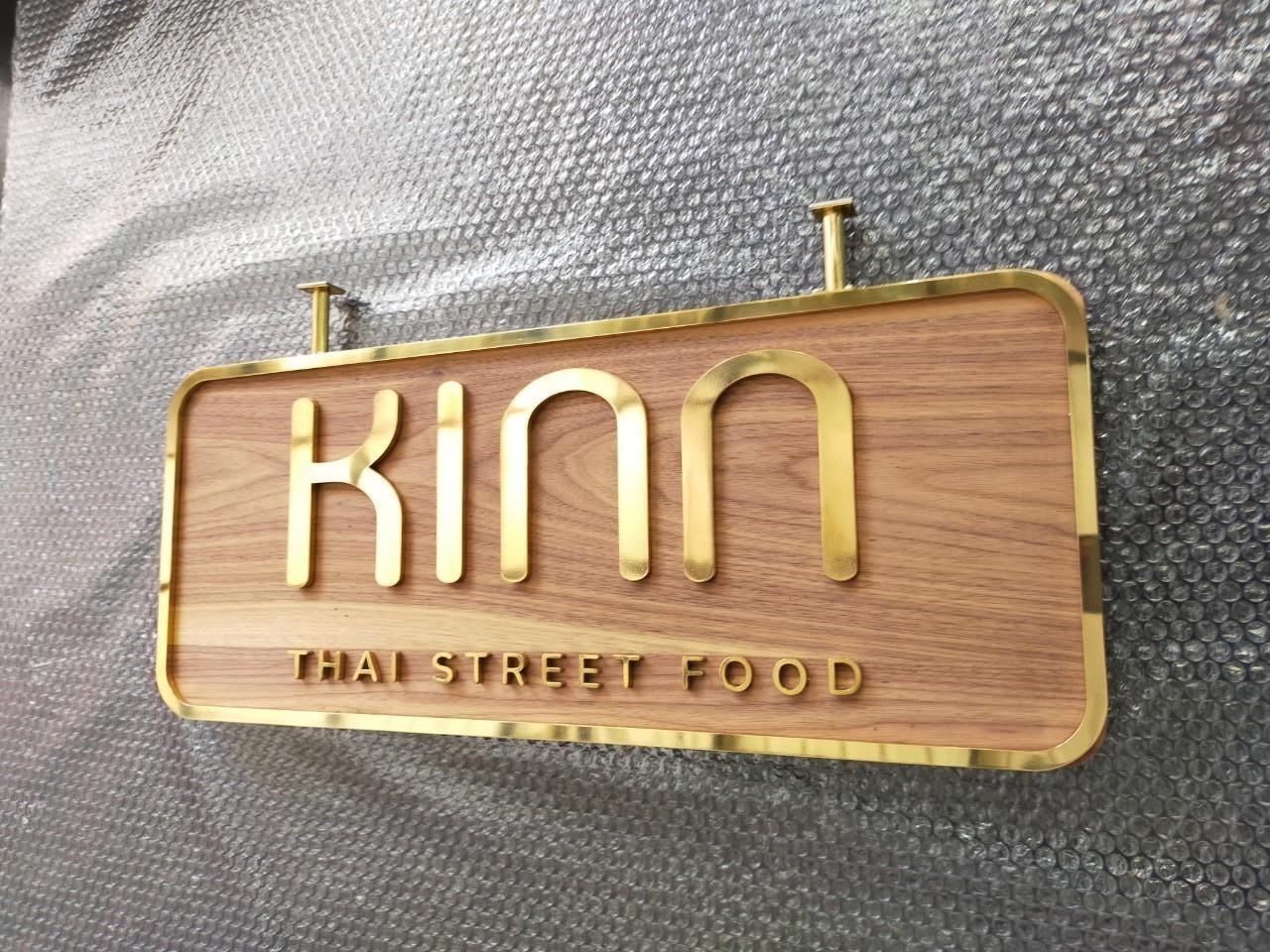 ป้ายอักษรทองเหลืองขัดเงา ยกขอบ รองพื้นไม้